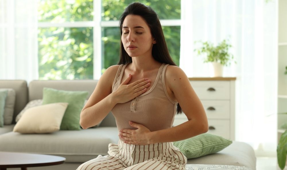 Mujer con ansiedad tocándose el pecho y el vientre para tratar la ansiedad con terapia EMDR